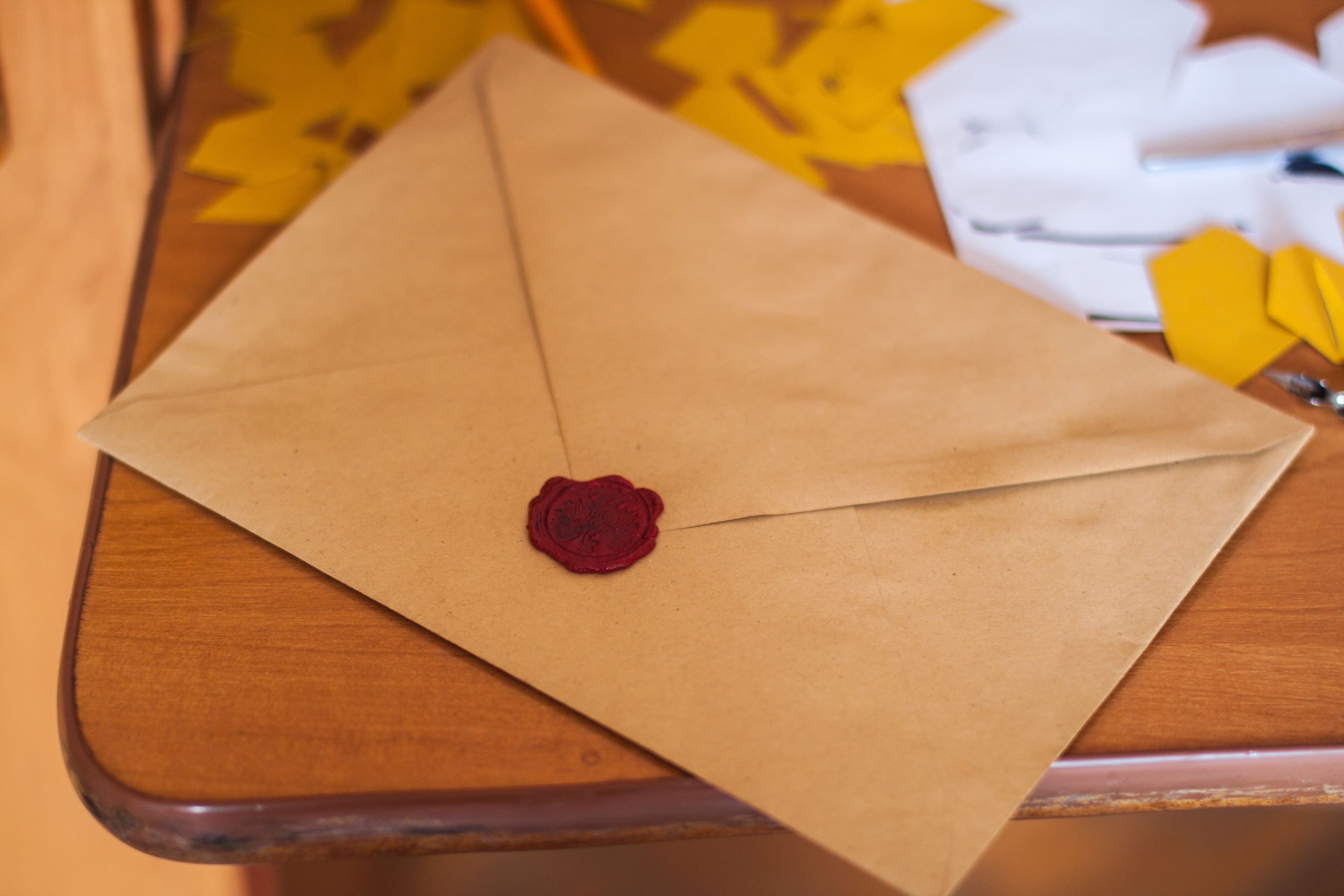 A wax-sealed envelope on a wooden table.