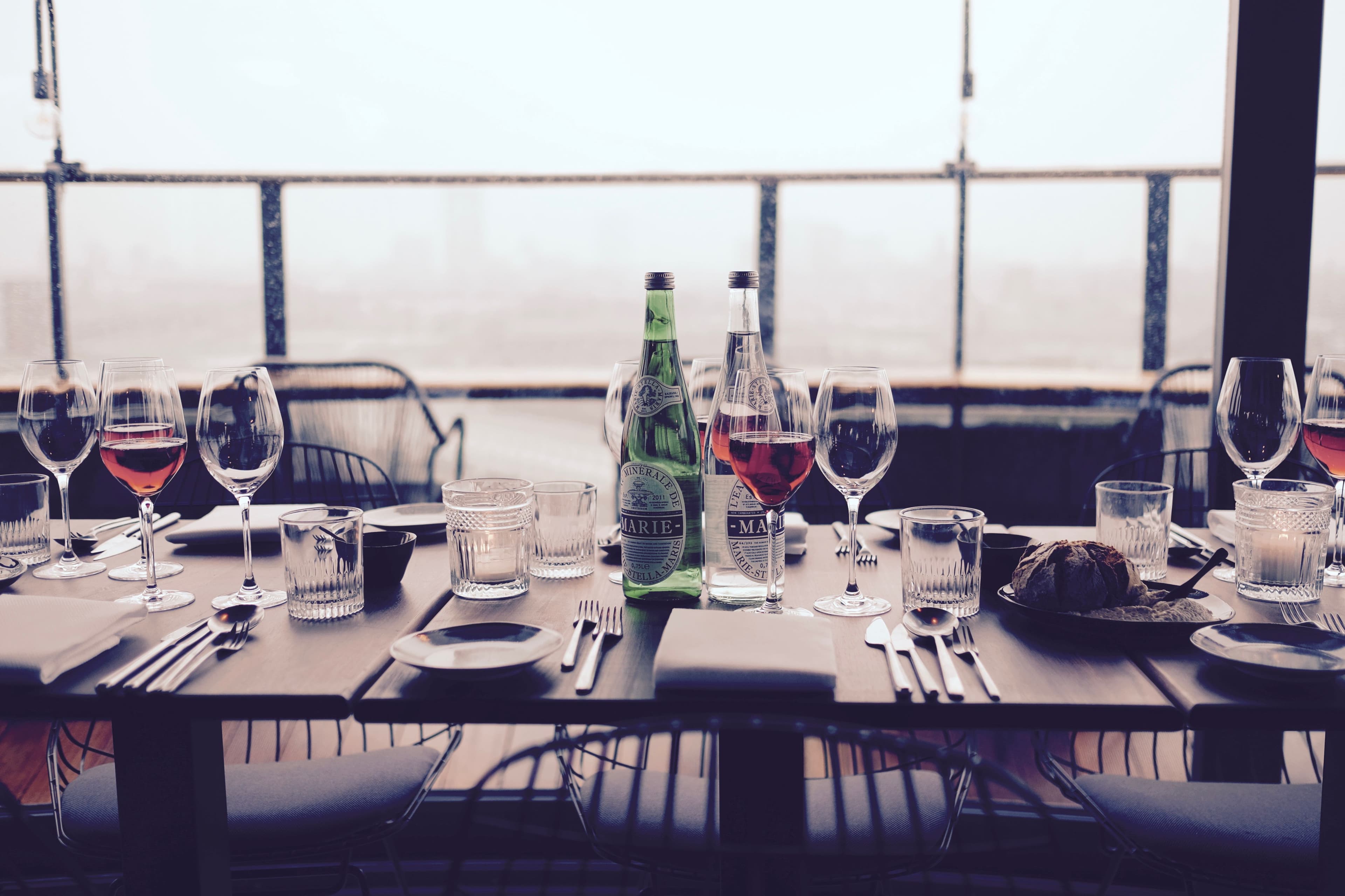 A set table with wine glasses and bread.