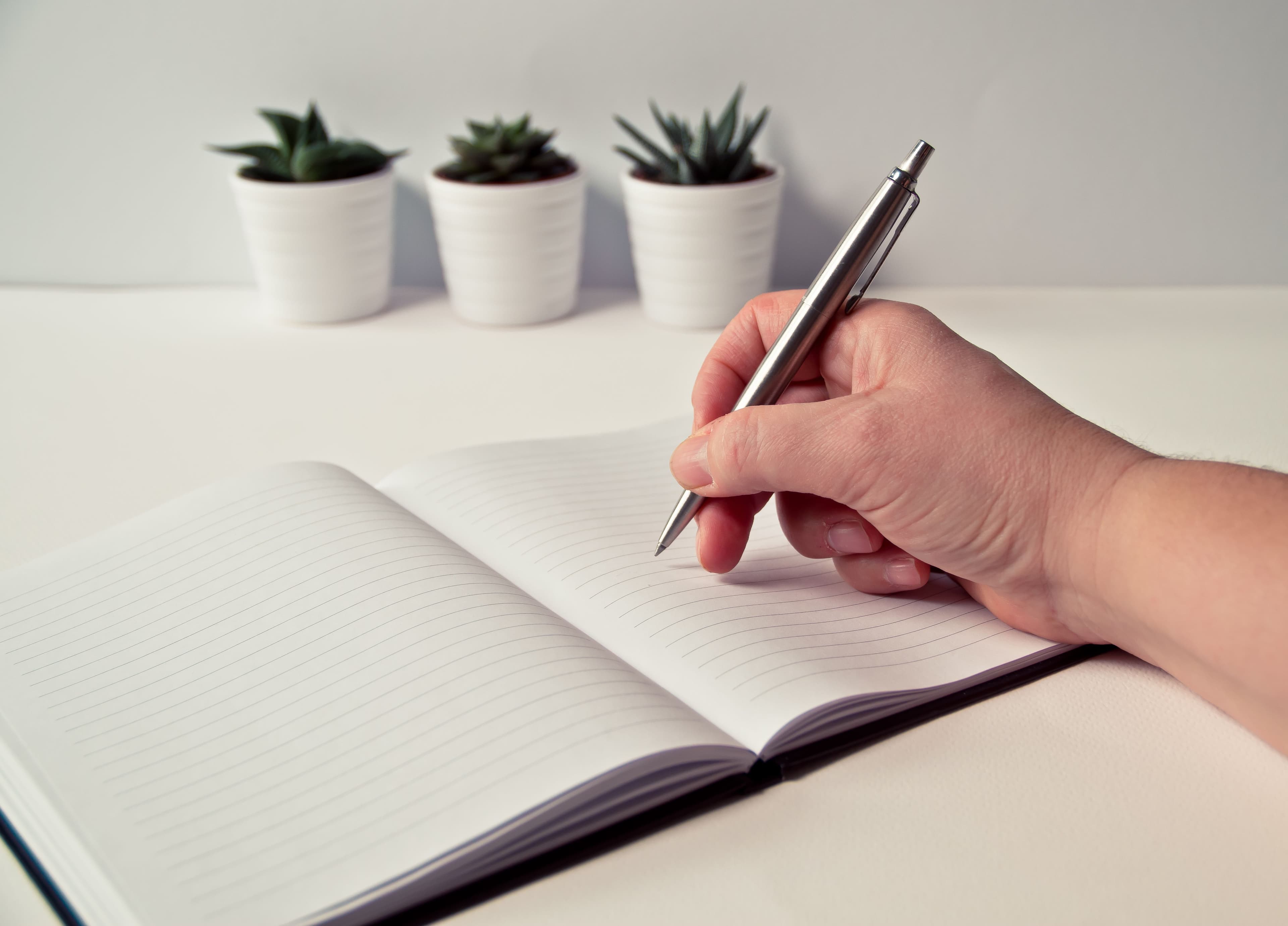 A hand writing in a notebook.